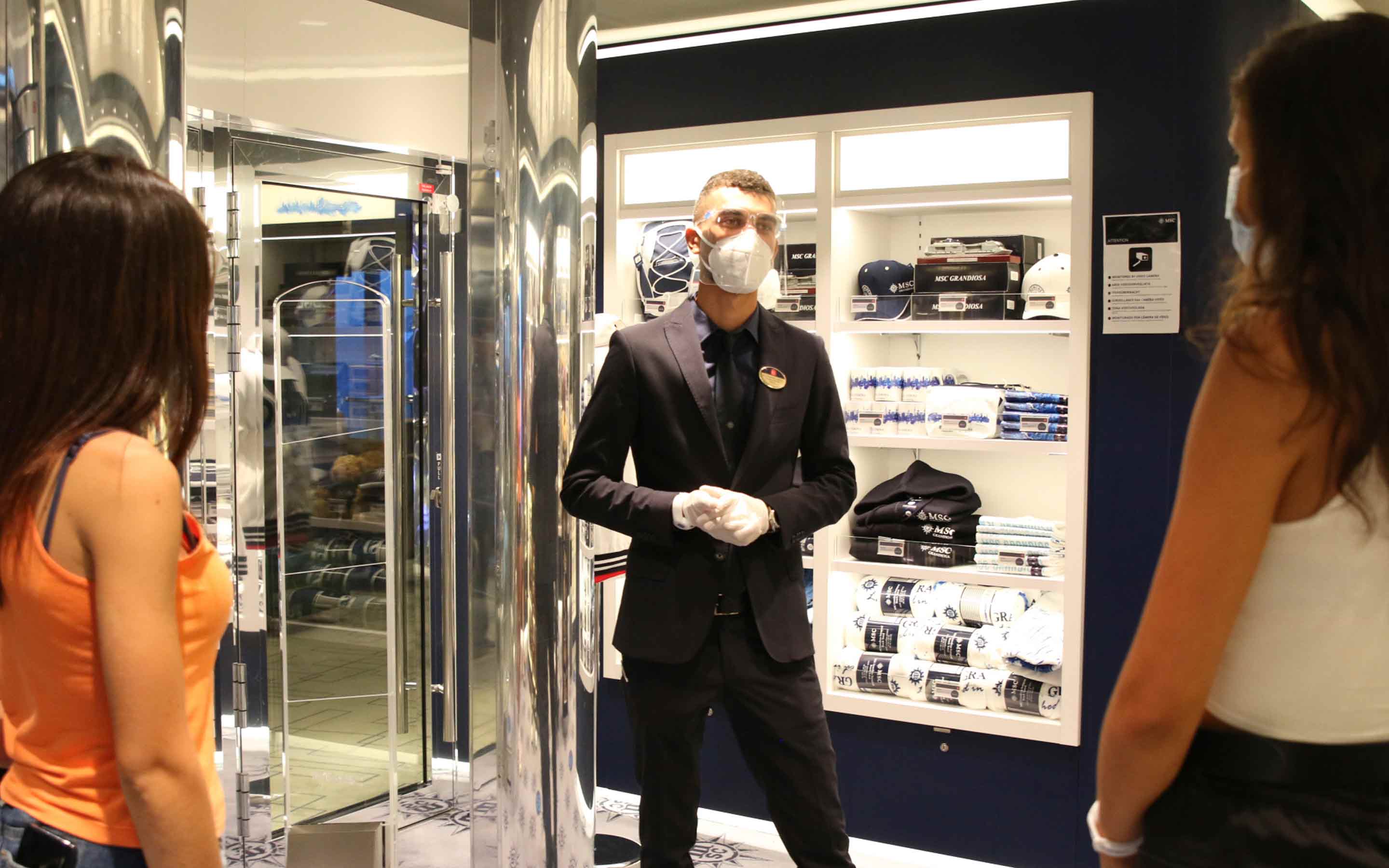 A crew member assisting guests in a stylish onboard shop | MSC Cruises