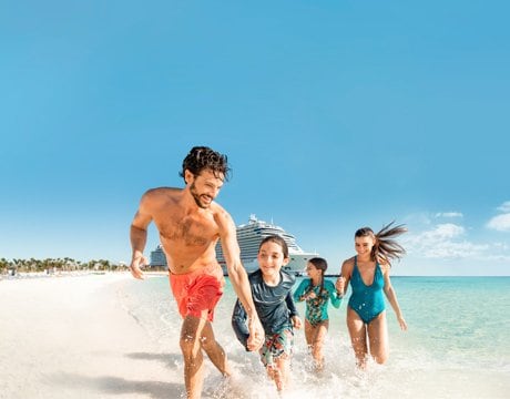 A family running on a sunny beach with an MSC cruise ship in the background | MSC Cruises A family running on a sunny beach with an MSC cruise ship in the background | MSC Cruises