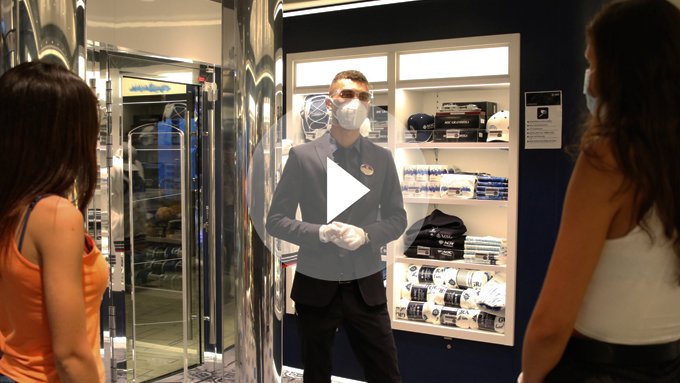 Crew member assisting guests in an onboard boutique with MSC merchandise | MSC Cruises