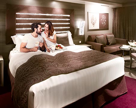 Couple enjoying a luxurious bed in an MSC cruise ship cabin | MSC Cruises