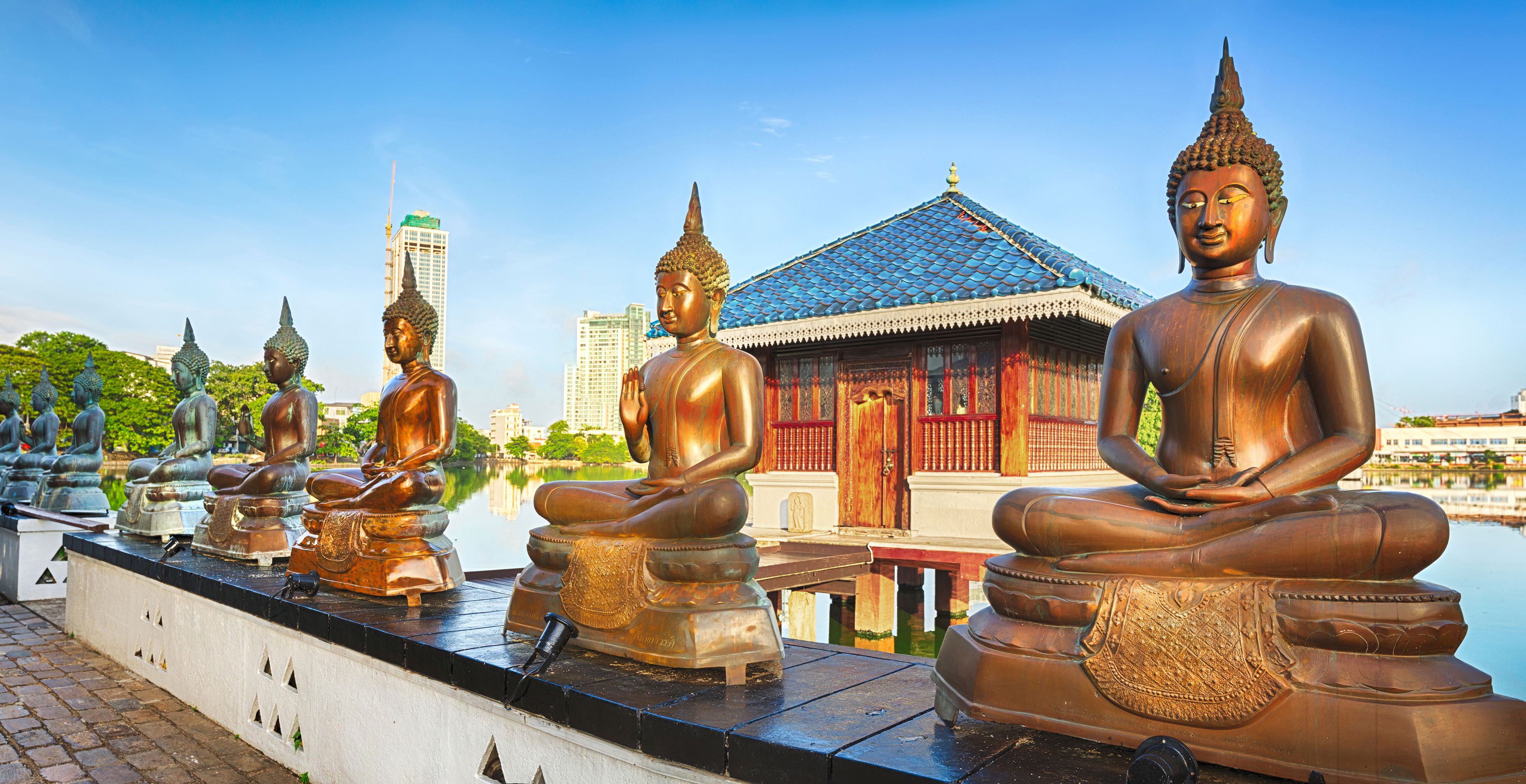 Bronze Buddha statues overlooking a serene lake and a temple in Colombo, Sri Lanka | MSC Cruises