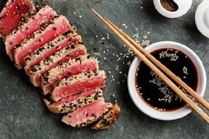 Sliced sesame-crusted tuna with soy sauce and chopsticks | MSC Cruises Sliced sesame-crusted tuna with soy sauce and chopsticks | MSC Cruises