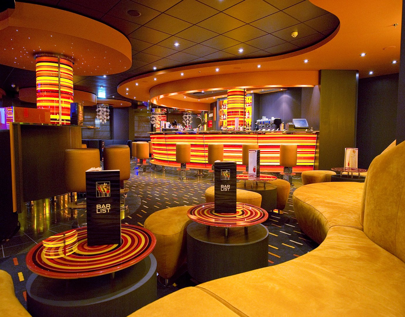 A vibrant onboard bar with colorful seating and illuminated decor | MSC Cruises A vibrant onboard bar with colorful seating and illuminated decor | MSC Cruises