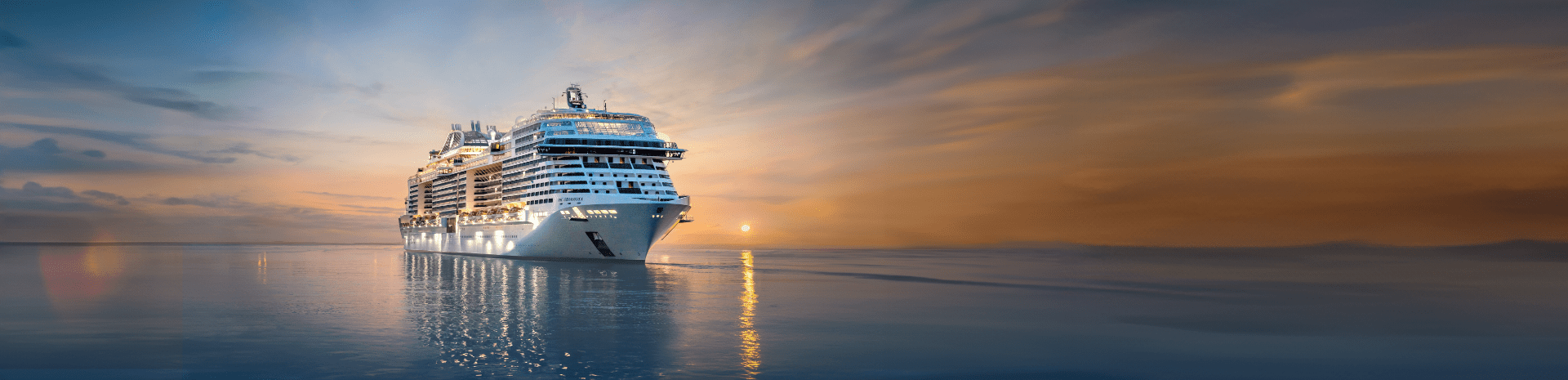 MSC Cruises ship MSC Grandiosa sailing on the open ocean with a setting sun in the background. MSC Cruises ship MSC Grandiosa sailing on the open ocean with a setting sun in the background.