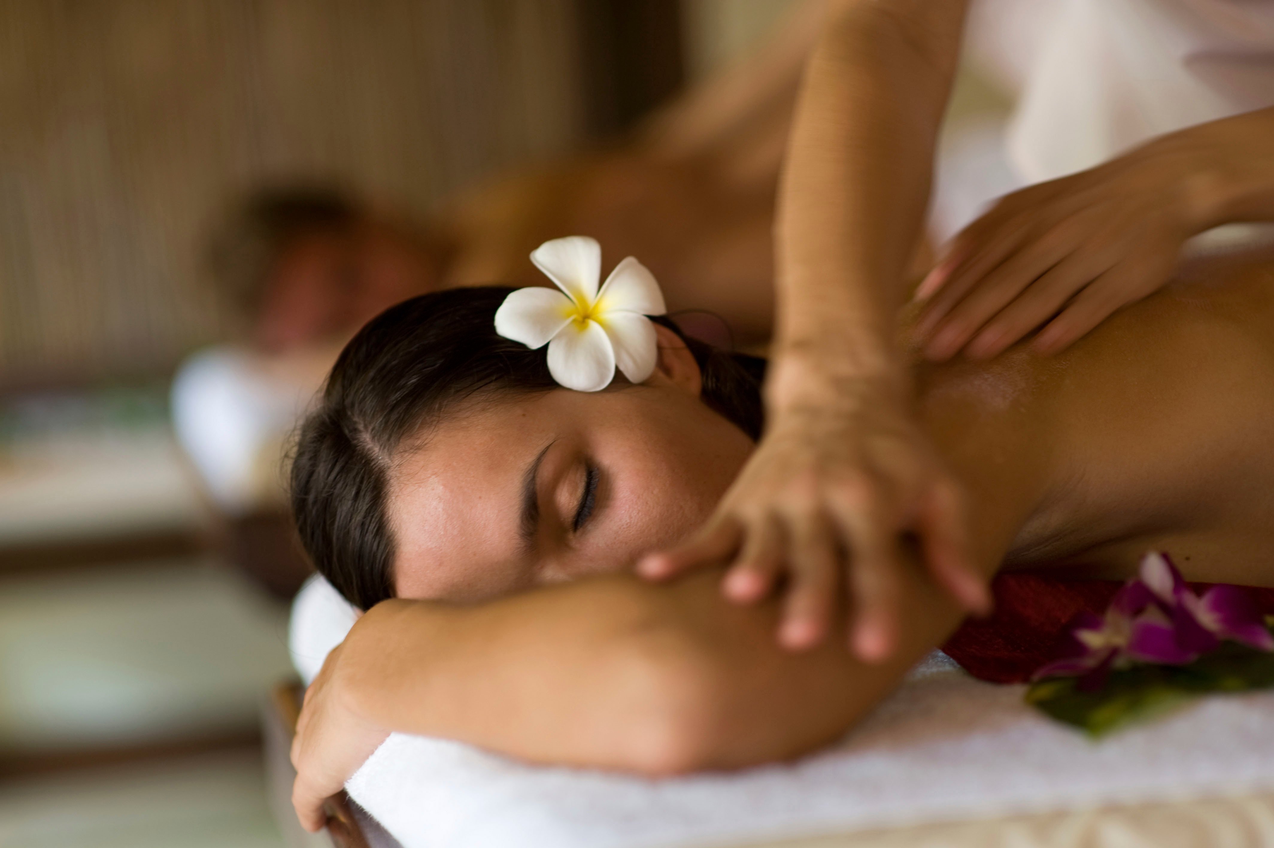 Woman enjoying a relaxing massage with tropical flowers onboard | MSC Cruises