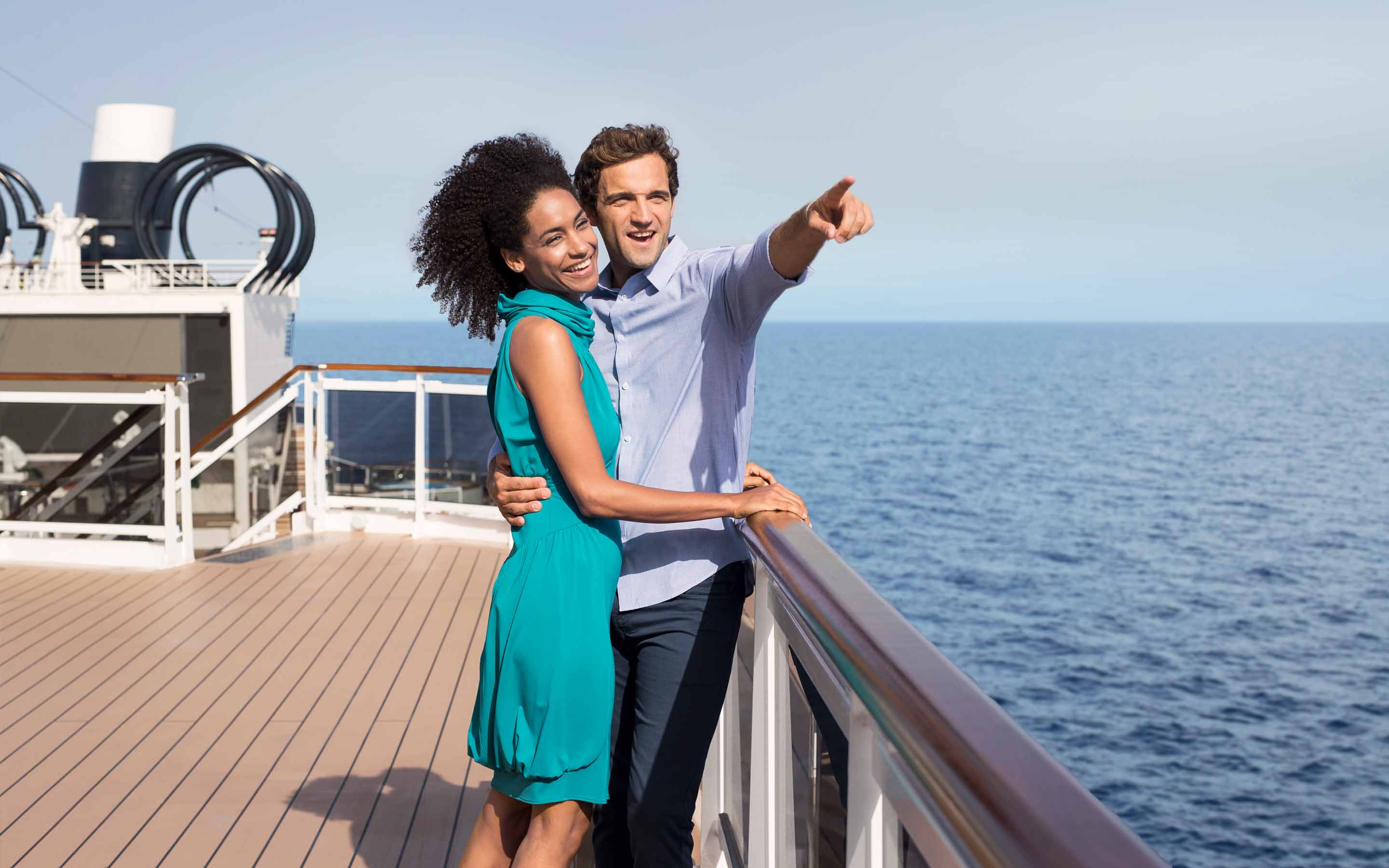A couple enjoying the ocean view from their cruise ship balcony | MSC Cruises A couple enjoying the ocean view from their cruise ship balcony | MSC Cruises