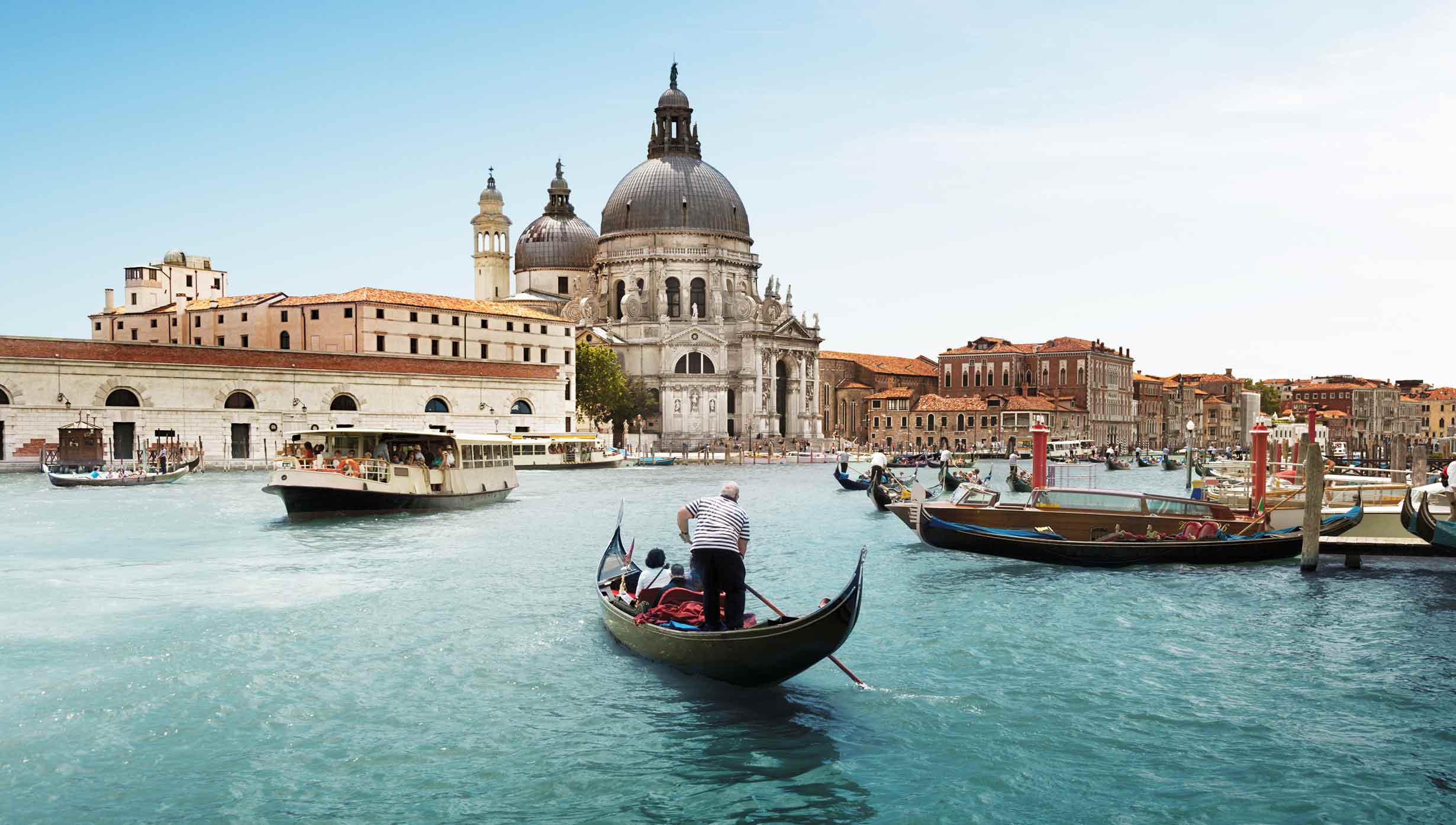 A gondola on Venice's Grand Canal with Santa Maria della Salute in the background | MSC Cruises