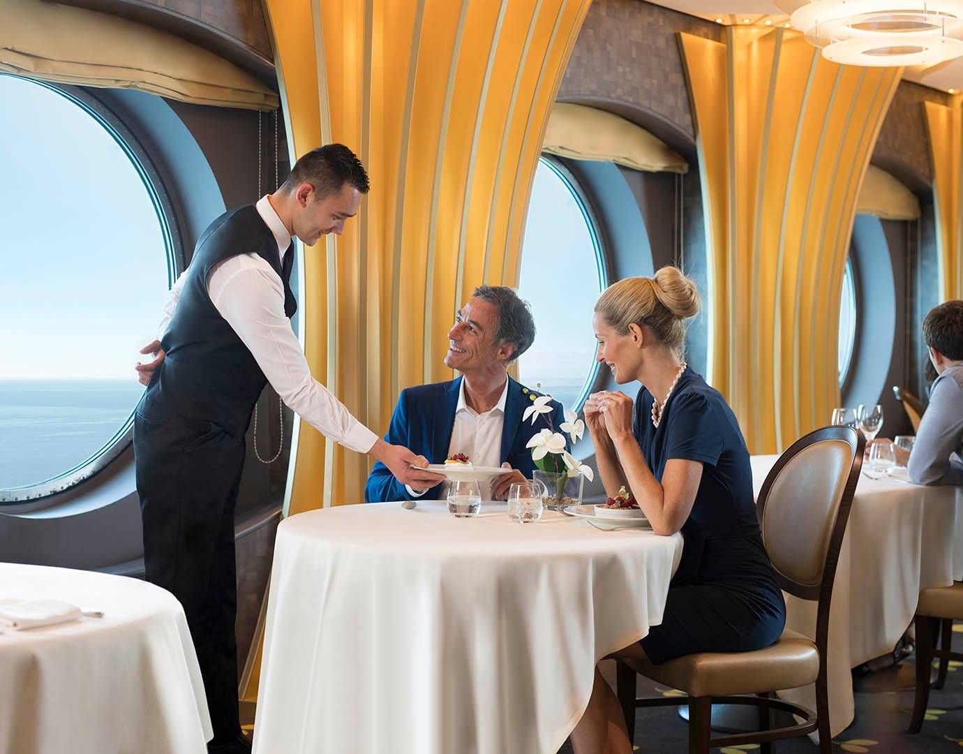 Elegant dining area with ocean views and attentive service aboard a cruise ship | MSC Cruises Elegant dining area with ocean views and attentive service aboard a cruise ship | MSC Cruises