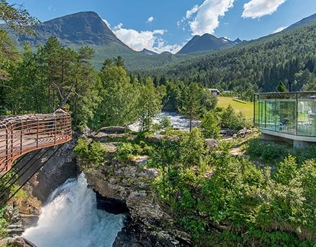 A scenic waterfall surrounded by lush greenery and mountains in Norway | MSC Cruises