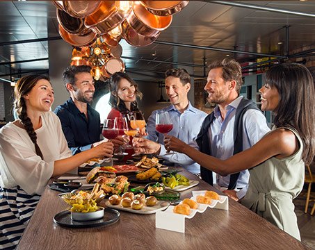Guests enjoying a gourmet dining experience with wine onboard | MSC Cruises
