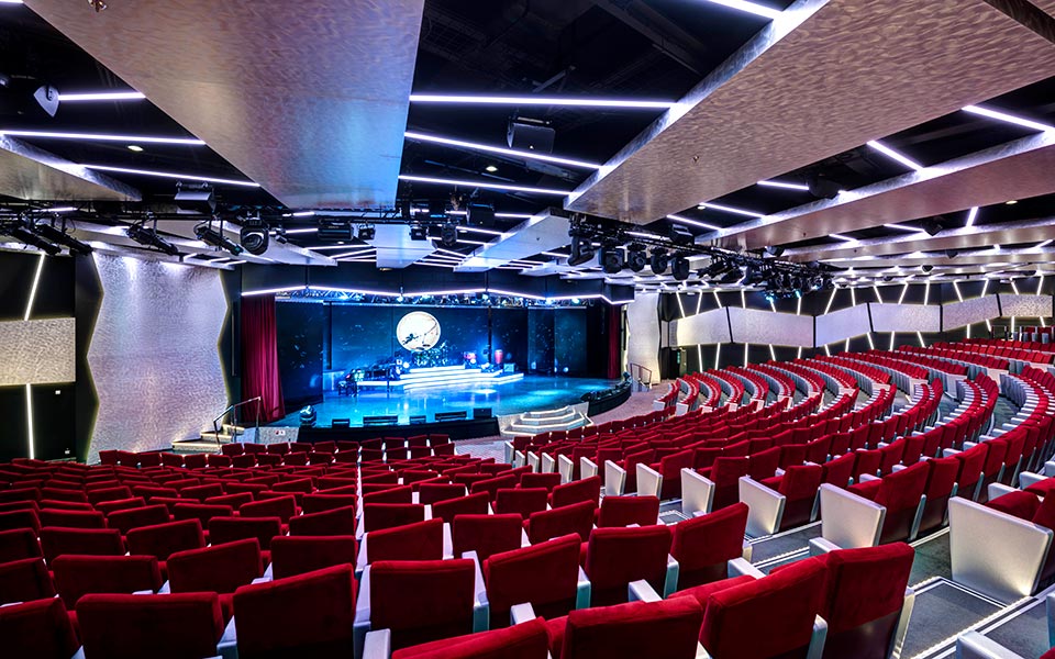 A modern theater with red seats and a stage on an MSC cruise ship | MSC Cruises A modern theater with red seats and a stage on an MSC cruise ship | MSC Cruises