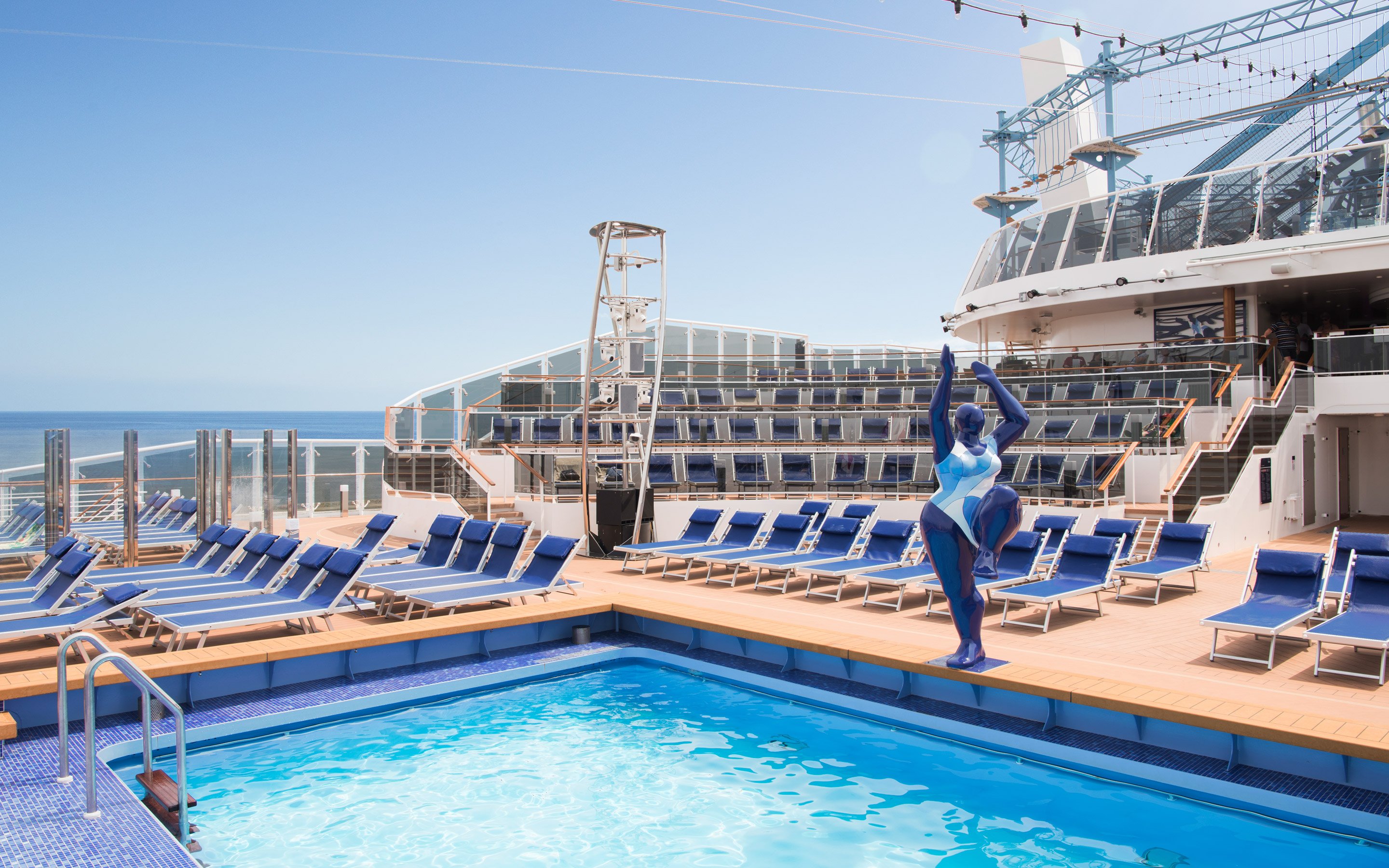 Sun deck with pool, lounge chairs, and modern sculpture on an MSC cruise ship | MSC Cruises