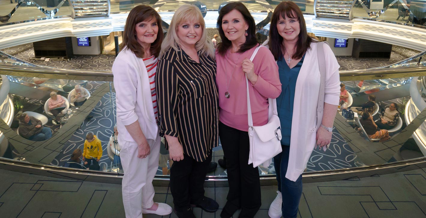 Passengers enjoying a modern cruise ship atrium with elegant decor and seating areas | MSC Cruises