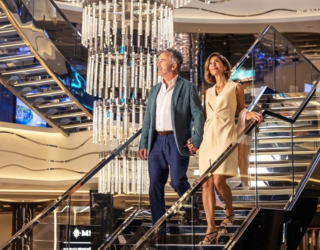 Older couple walking down spiral staircase aboard a MSC Cruises cruise ship with crystal chandelier hanging in the background. Older couple walking down spiral staircase aboard a MSC Cruises cruise ship with crystal chandelier hanging in the background.