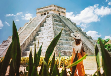 A traveler admiring Chichen Itza under a sunny sky | MSC Cruises A traveler admiring Chichen Itza under a sunny sky | MSC Cruises